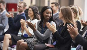 A group of people are clapping a conference