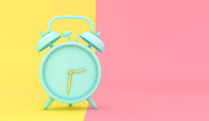A green clock is against a yellow and a pink background