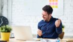 A photo of someone celebrating at a desk