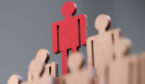 Red wooden figurine standing above others closeup