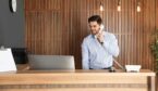 Receptionist talking on phone at desk in lobby