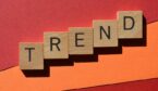 Trend, word in wooden alphabet letters isolated on red and orange background