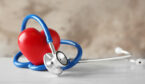 Stethoscope and red heart on table