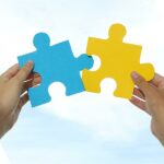 Partnership concept with two hands putting puzzle pieces together