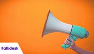 A hand is holding megaphone on orange background, announcement concept