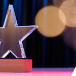Star shape trophy with color light against stage curtain