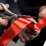 Business people hands cutting red ribbon - opening ceremony