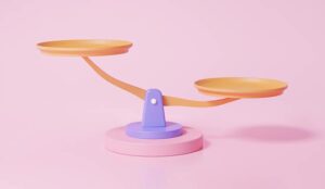 Weighing scales on pink background - balance concept