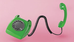 Old telephone on a pink background