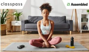 woman in activewear practicing yoga on a mat in a cozy living room setting.