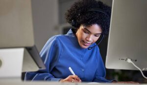 Call centre agent writing in a notebook