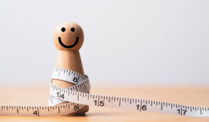 wooden figure with measuring tape