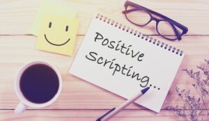 Writing positive scripting concept with a notepad and words